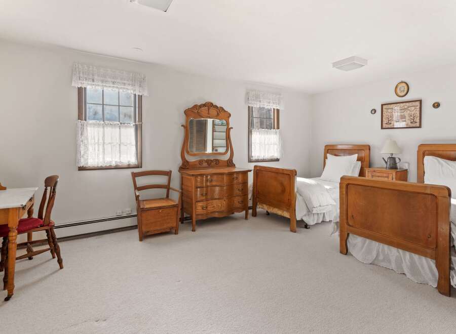 This charming bedroom features two antique wooden beds, perfect for a guest room or a cozy retreat.