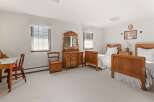 This charming bedroom features two antique wooden beds, perfect for a guest room or a cozy retreat.