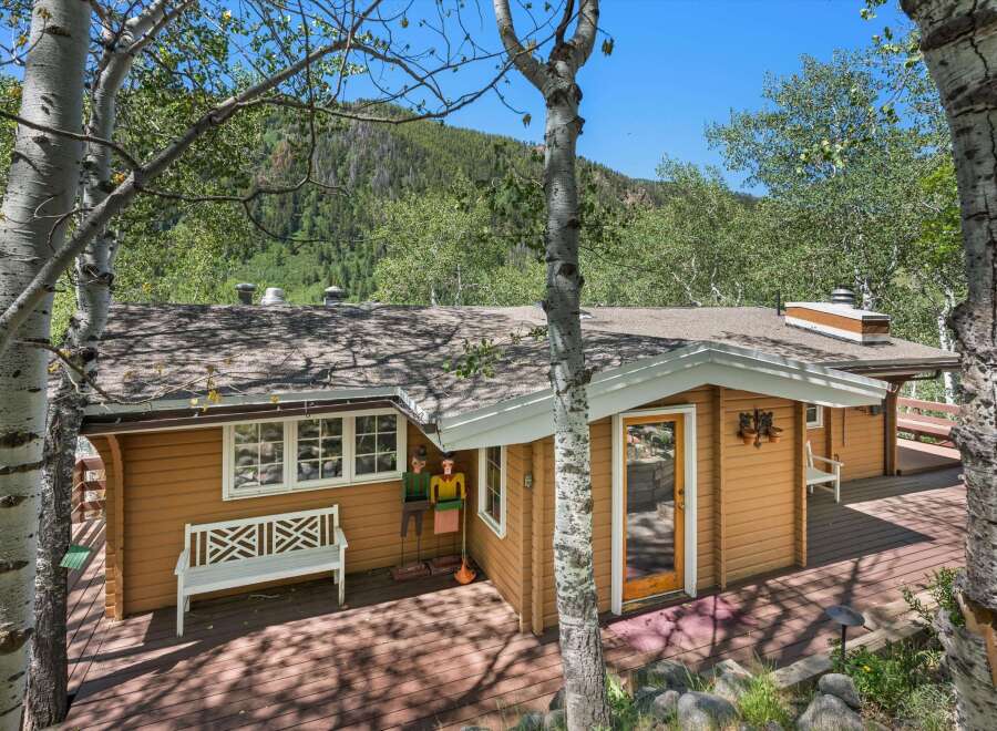 Nestled amidst lush greenery and mature trees, this charming home offers a serene mountain retreat.