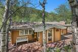 Nestled amidst lush greenery and mature trees, this charming home offers a serene mountain retreat.