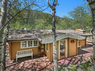 Nestled amidst lush greenery and mature trees, this charming home offers a serene mountain retreat.
