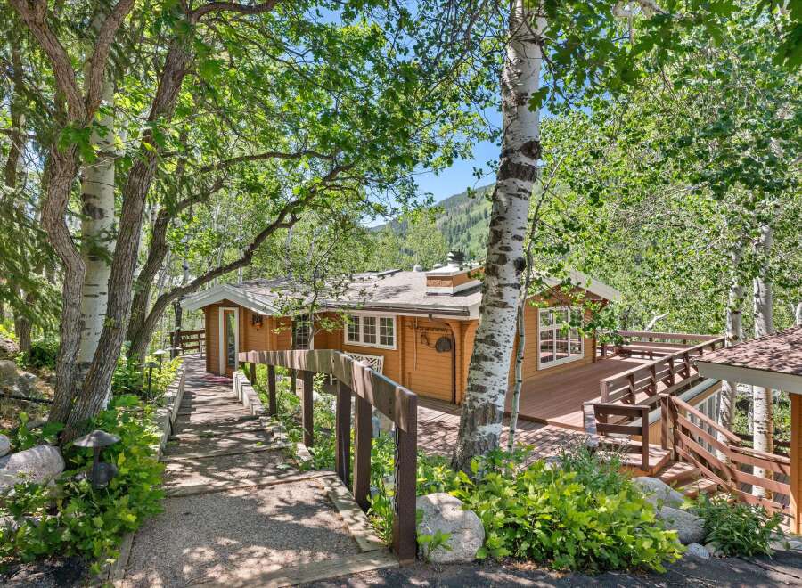 Nestled amidst lush greenery and mature trees, this charming home offers a serene mountain retreat.