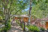 Nestled amidst lush greenery and mature trees, this charming home offers a serene mountain retreat.