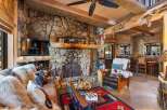Step into rustic luxury with this stunning property featuring a grand stone fireplace, perfect for cozy evenings.