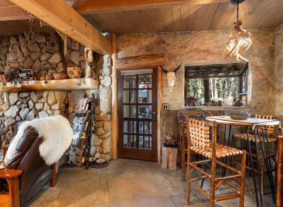 Step into rustic elegance with this stunning property, featuring a cozy stone fireplace and exposed wooden beams.