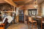 Step into rustic elegance with this stunning property, featuring a cozy stone fireplace and exposed wooden beams.