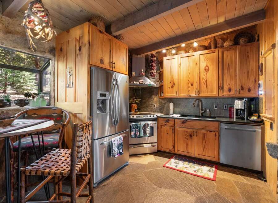Step into rustic elegance with this stunning kitchen! Featuring custom wood cabinetry, stainless steel appliances, and a unique stone backsplash, this space is perfect for both cooking and entertaining.