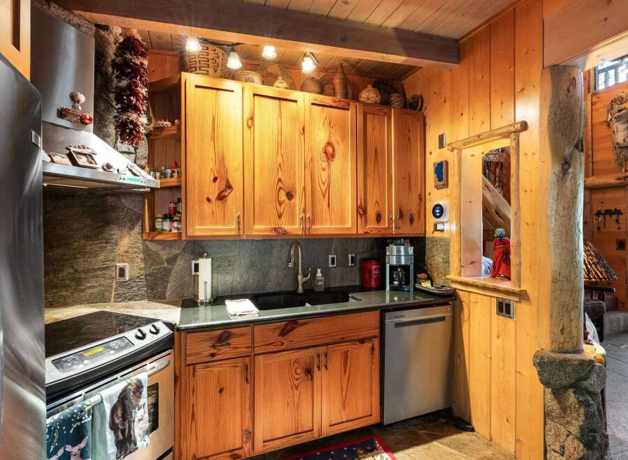 This charming kitchen boasts rustic wooden cabinetry and a sleek, modern countertop, creating a perfect blend of style and functionality.