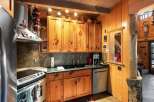 This charming kitchen boasts rustic wooden cabinetry and a sleek, modern countertop, creating a perfect blend of style and functionality.