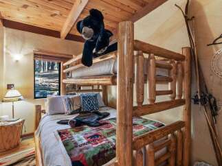 This cozy cabin bedroom features a rustic bunk bed, perfect for a family getaway.