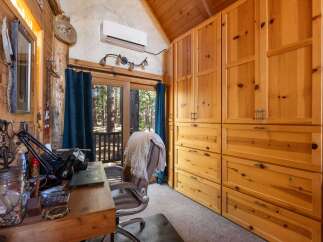Step into this charming cabin office, featuring a cozy workspace with a view.
