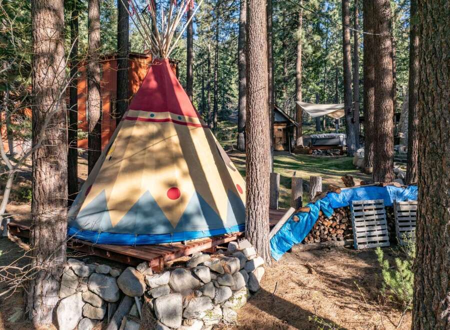 Escape to this unique property featuring a charming teepee nestled in a serene forest setting.