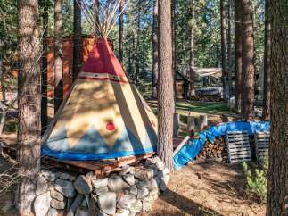 Escape to this unique property featuring a charming teepee nestled in a serene forest setting.
