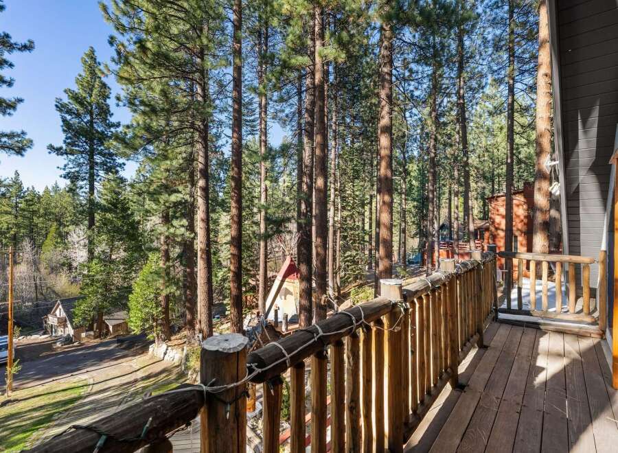 Enjoy the tranquility of nature from this stunning property! This home features a beautiful wooden deck that overlooks a lush forest of tall trees.