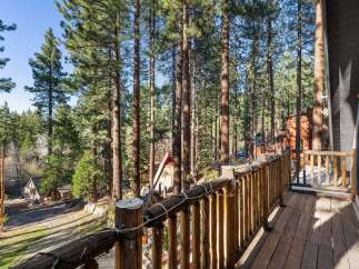 Enjoy the tranquility of nature from this stunning property! This home features a beautiful wooden deck that overlooks a lush forest of tall trees.