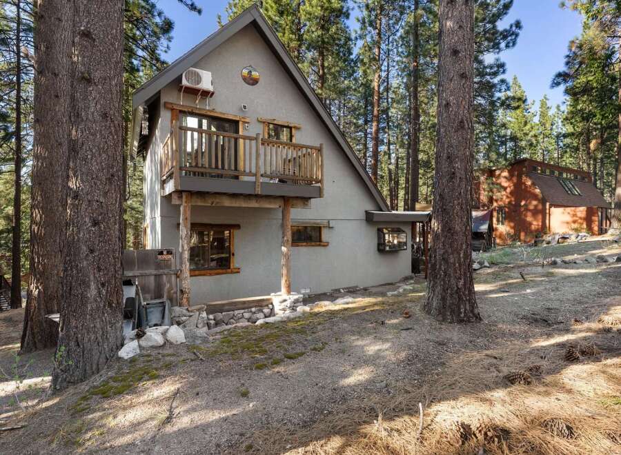 Nestled amidst towering trees, this charming A-frame cabin offers a serene escape.