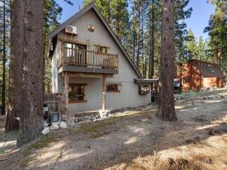 Nestled amidst towering trees, this charming A-frame cabin offers a serene escape.