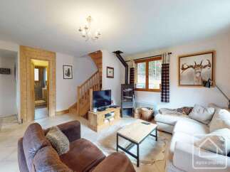 This cozy living room features a rustic design with wooden accents and a warm fireplace, perfect for relaxing evenings.