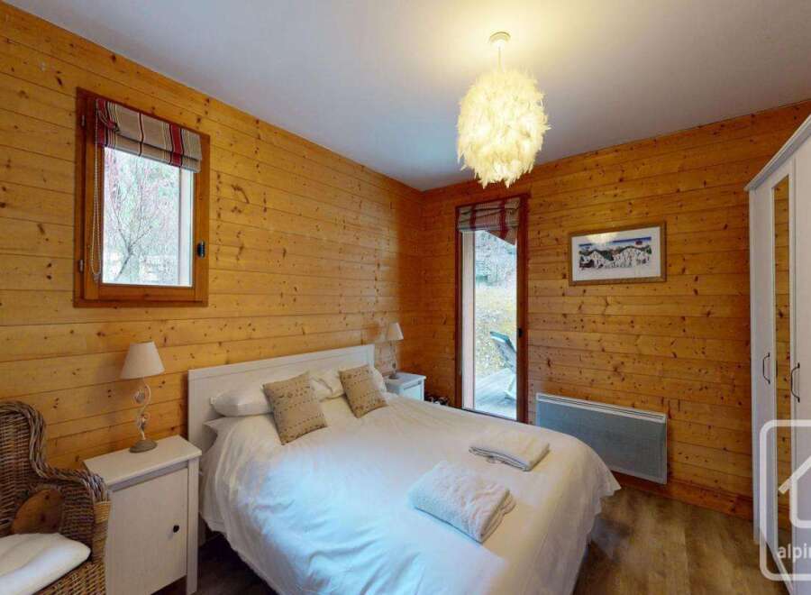 This cozy bedroom features warm wooden paneling, creating a rustic and inviting atmosphere.