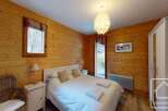 This cozy bedroom features warm wooden paneling, creating a rustic and inviting atmosphere.
