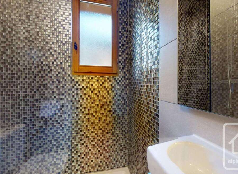 This stunning bathroom boasts a unique mosaic tile design that adds a touch of luxury and sophistication.