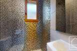 This stunning bathroom boasts a unique mosaic tile design that adds a touch of luxury and sophistication.