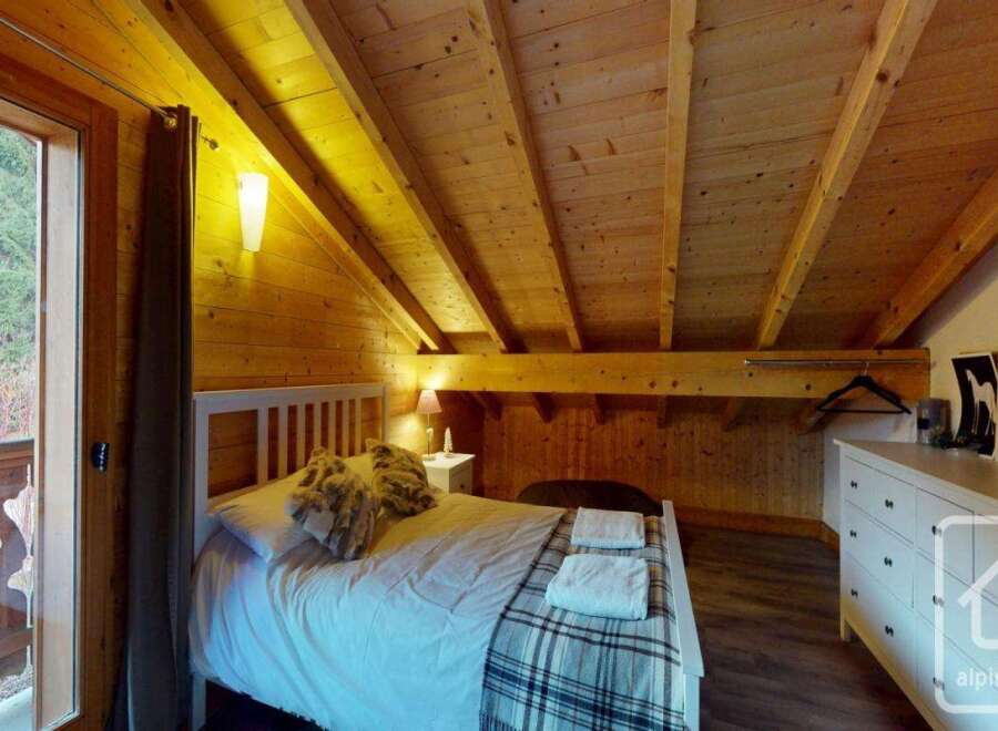 This charming bedroom features a cozy wooden interior, creating a warm and inviting atmosphere.
