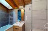 This stunning bathroom features a modern design with a wooden vanity and a sleek sink.