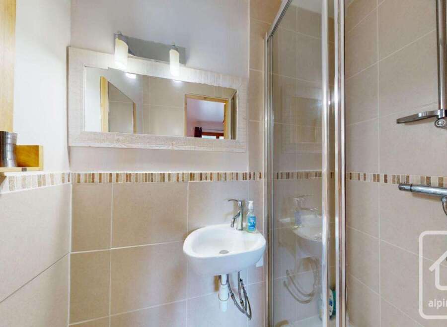 This charming bathroom features a modern design with a sleek sink and a glass shower enclosure.