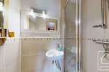 This charming bathroom features a modern design with a sleek sink and a glass shower enclosure.