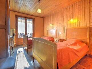 This charming bedroom features two cozy beds with warm orange bedding, perfect for a relaxing stay.