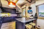 This stunning kitchen boasts a modern design with dark cabinetry and a striking granite countertop, perfect for culinary enthusiasts.