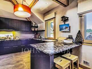 This stunning kitchen boasts a modern design with dark cabinetry and a striking granite countertop, perfect for culinary enthusiasts.