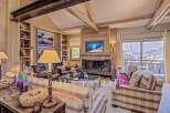 Experience luxury living in this stunning property, featuring a cozy living room with a fireplace and a large window offering breathtaking views.