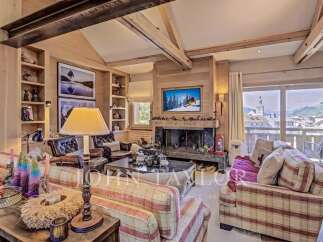 Experience luxury living in this stunning property, featuring a cozy living room with a fireplace and a large window offering breathtaking views.