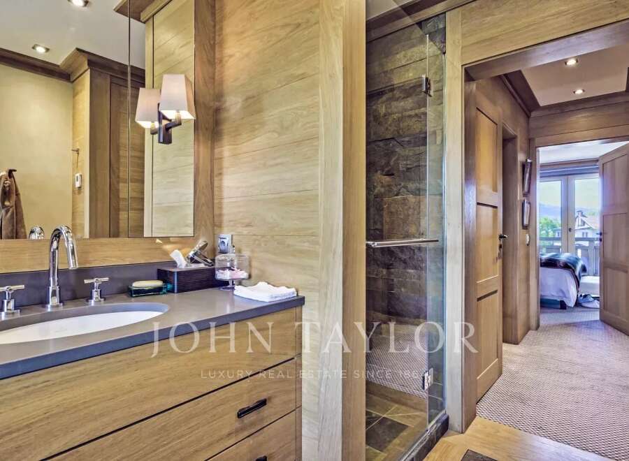 This luxurious bathroom boasts a sleek, modern design with natural wood accents and a spacious layout.