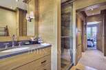 This luxurious bathroom boasts a sleek, modern design with natural wood accents and a spacious layout.