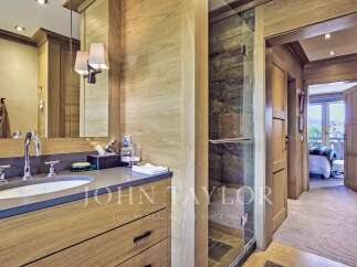 This luxurious bathroom boasts a sleek, modern design with natural wood accents and a spacious layout.
