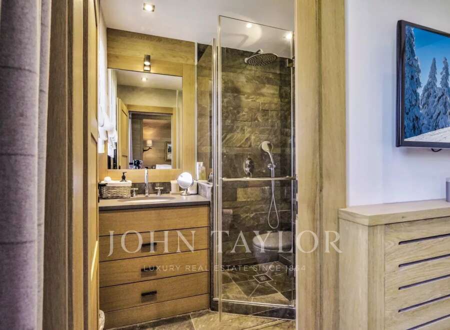 Step into luxury with this stunning bathroom featuring a sleek shower and a modern vanity.