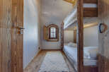 Step into this charming bedroom featuring rustic wooden bunk beds and a cozy ambiance.