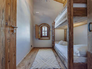 Step into this charming bedroom featuring rustic wooden bunk beds and a cozy ambiance.