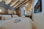 Experience luxury in this stunning bedroom featuring a cozy bed, plush pillows, and rolled towels.