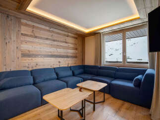 Experience luxury living in this stunning property featuring a cozy sectional sofa, perfect for relaxing after a day on the slopes.