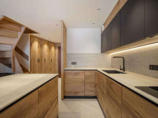 This stunning kitchen boasts a modern design with sleek wooden cabinetry and countertops.