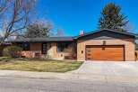 This stunning brick home boasts a modern design with a beautiful wooden garage door.