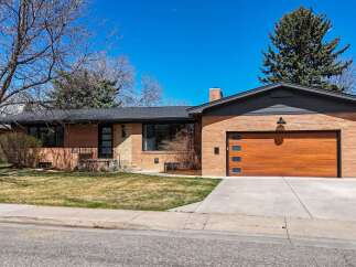 This stunning brick home boasts a modern design with a beautiful wooden garage door.