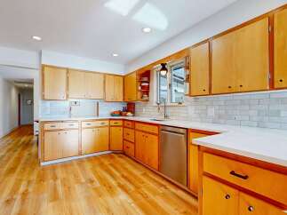Step into this stunning kitchen, boasting beautiful wooden cabinetry and sleek countertops.