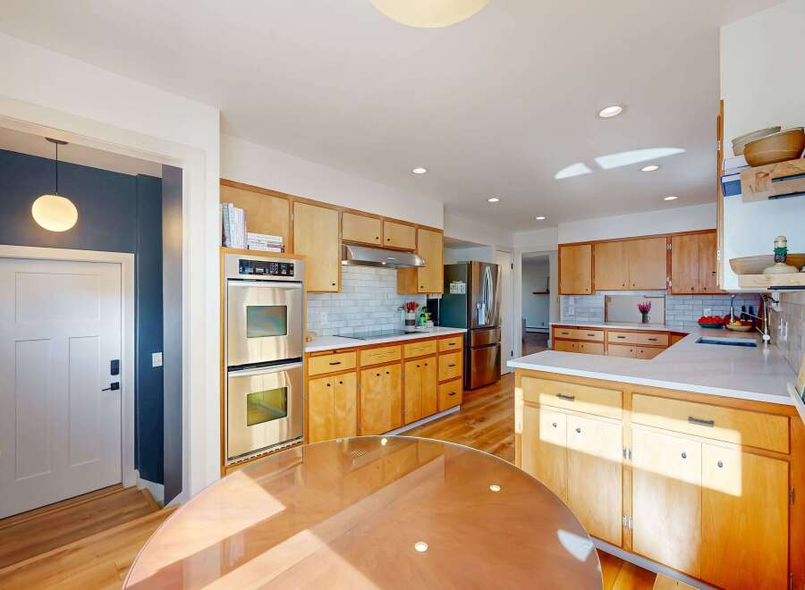 This stunning kitchen boasts a warm and inviting atmosphere with its natural wood cabinetry and sleek stainless steel appliances.