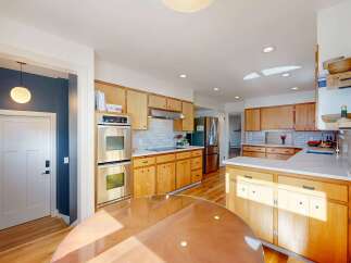 This stunning kitchen boasts a warm and inviting atmosphere with its natural wood cabinetry and sleek stainless steel appliances.