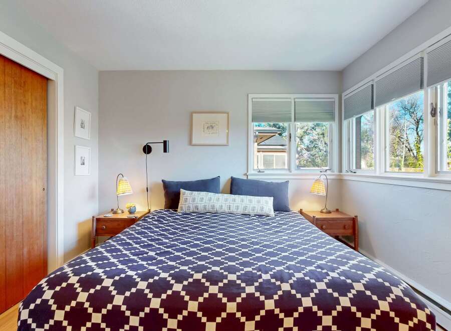 This cozy bedroom features a stylish bed with a geometric patterned comforter, creating a focal point in the room.